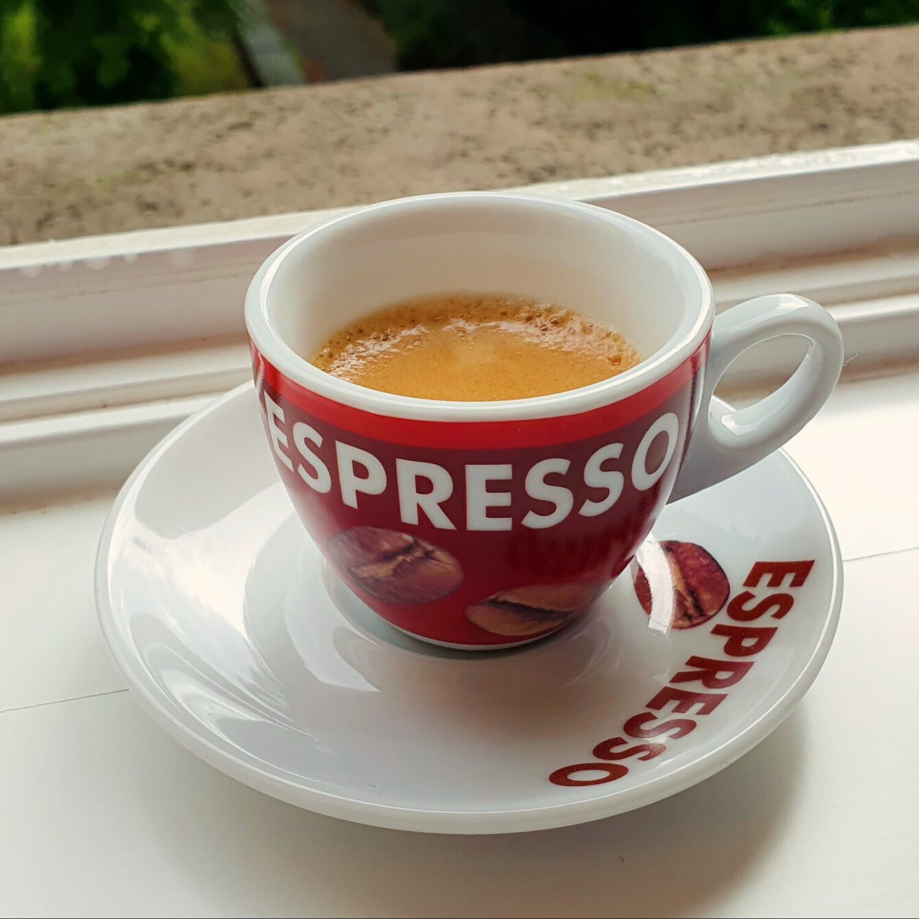 Fancy espresso cup on windowsill.
