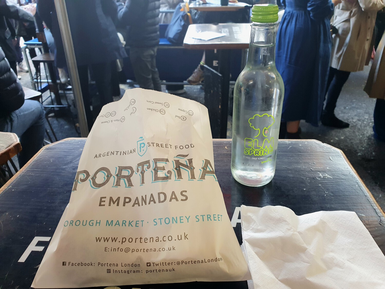 Argentinian empanadas packaging from Porteña street food at Borough Market, with Elm Spring water bottle.